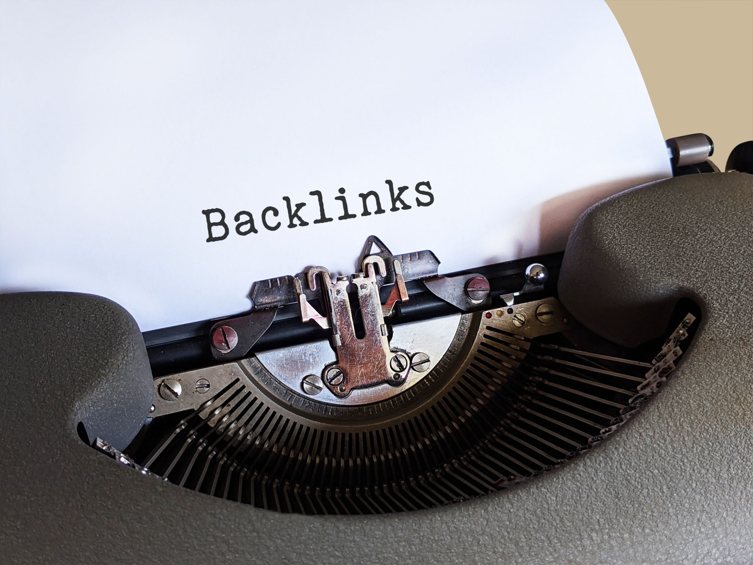 Vintage typewriter typing the word Backlinks, representing buying guest post backlinks safely